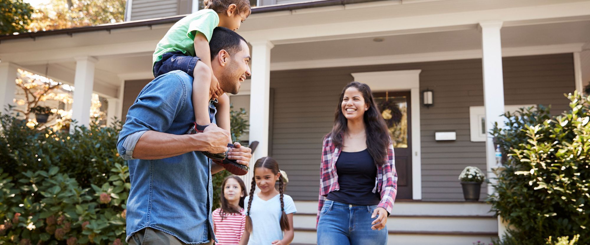 A smiling family stands in front of their home, symbolizing pride of homeownership and possibly a recent renovation or improvement. A smiling family stands in front of their home, symbolizing pride of homeownership and possibly a recent renovation or improvement.